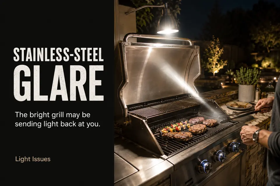 Stainless-steel grill reflecting an outdoor task light toward the cook’s position.